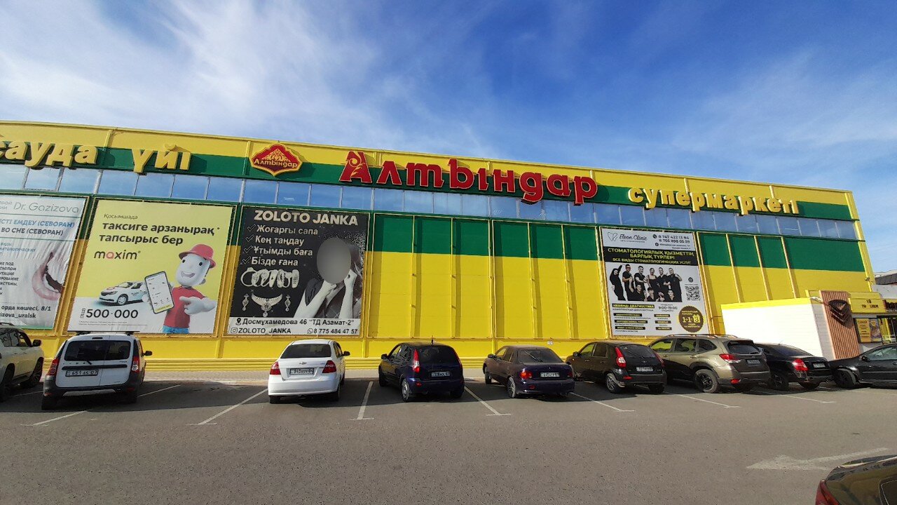 Altyndar supermarket in Kazakhstan: yellow and green facade with the Altyndar sign above the car park